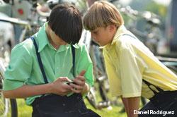 Two Amish boys texting on a cell phone