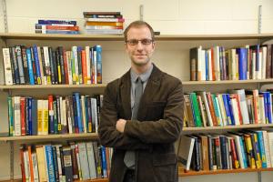 dr. michael pisapia in front of his bookshelves