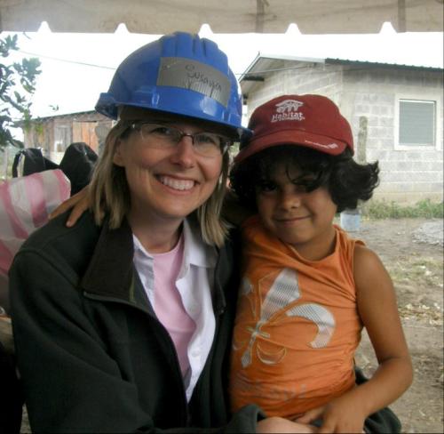 susan mapp with young child both wearing hard hats on service trip to hondorous