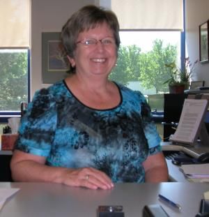 sandi hilsher at her desk in library