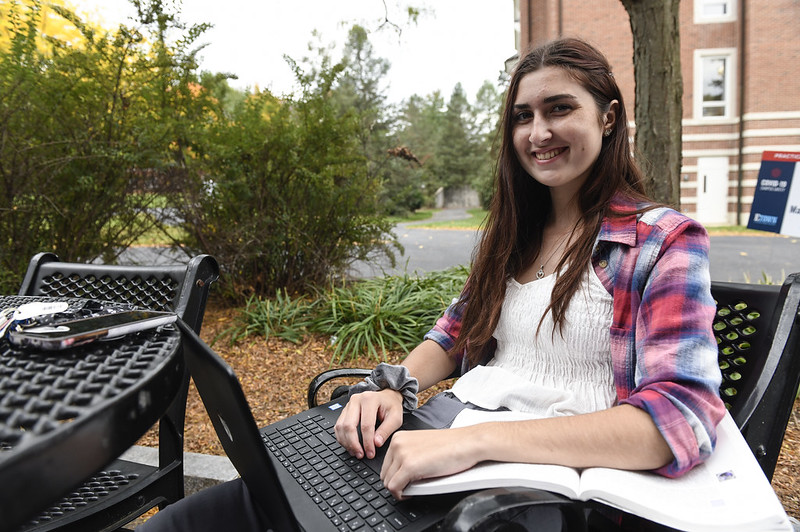 student sitting at table with laptop