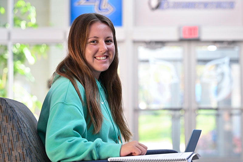 student sitting at table with laptop