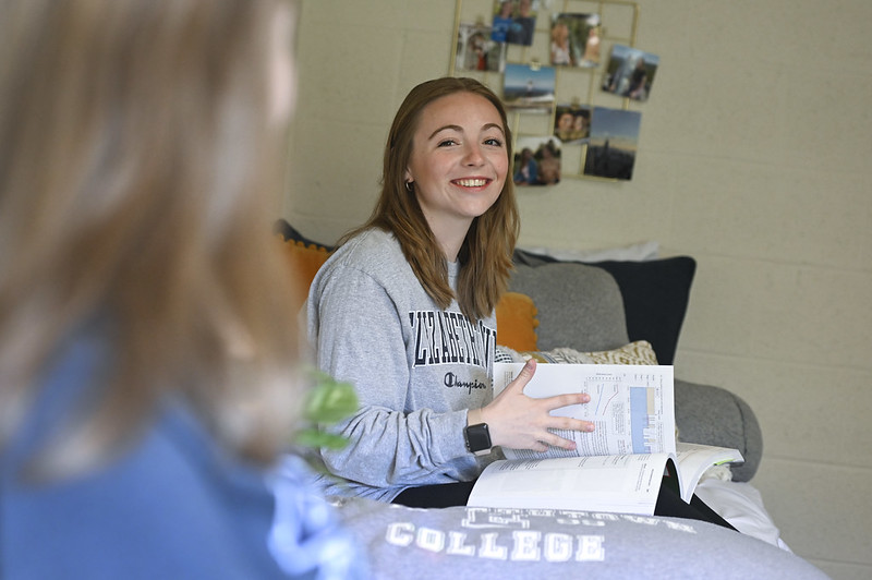 female student sitting on bed