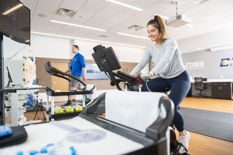 student riding exercise bike