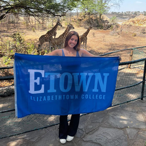 student in kenya with Etown flag